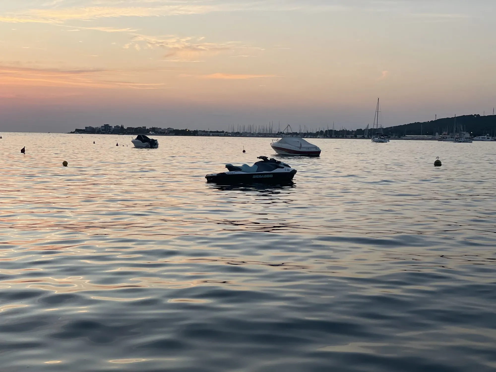 Vodni skuter Sea-Doo na mirnem morju ob sončnem zahodu